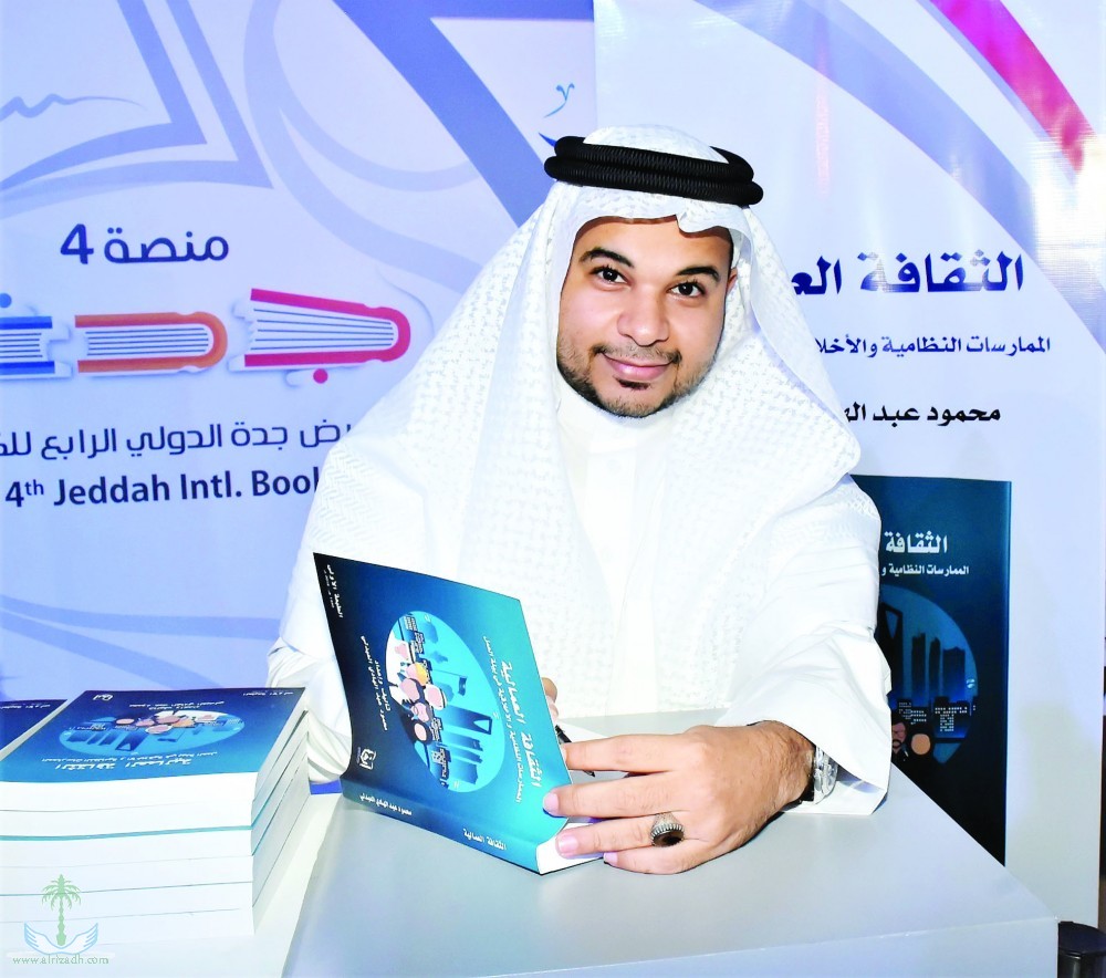 صورة محمود العبدلي وهو يوقع كتابه الأول في معرض جدة للكتاب